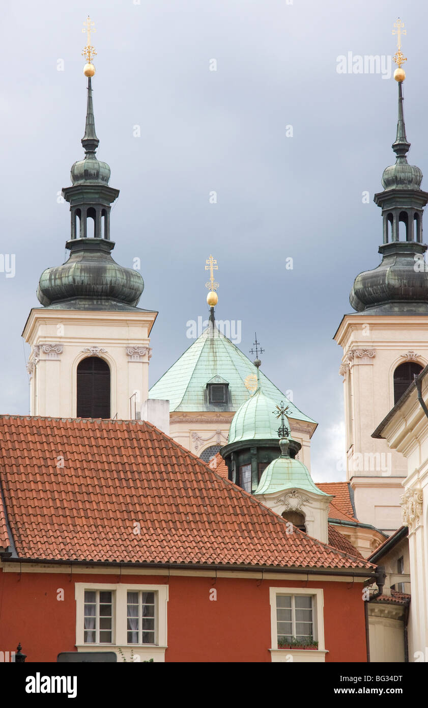 Renaissance church with belfries and crosses in back-street of Prague under stormy sky Stock Photo
