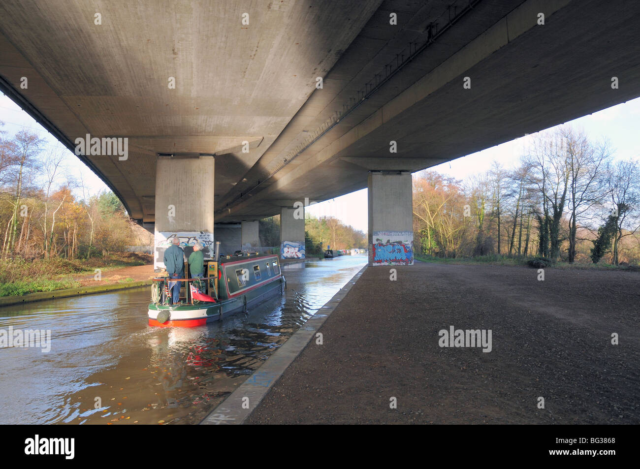 River Wey Navigation with canal boat passing under the M25 motorway at