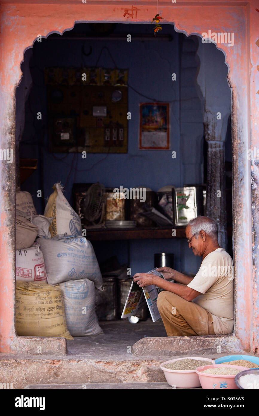 Merchant reading a newspaper in Pushkar India Stock Photo