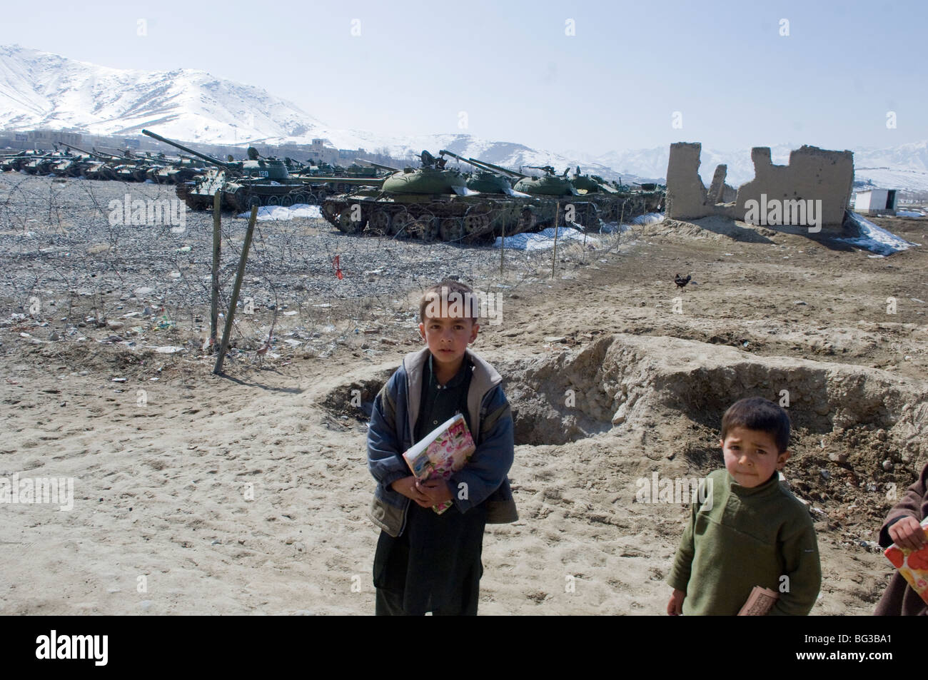 Afghan boys near old Russian T72 tanks in Kabul city, Afghanistan. Stock Photo