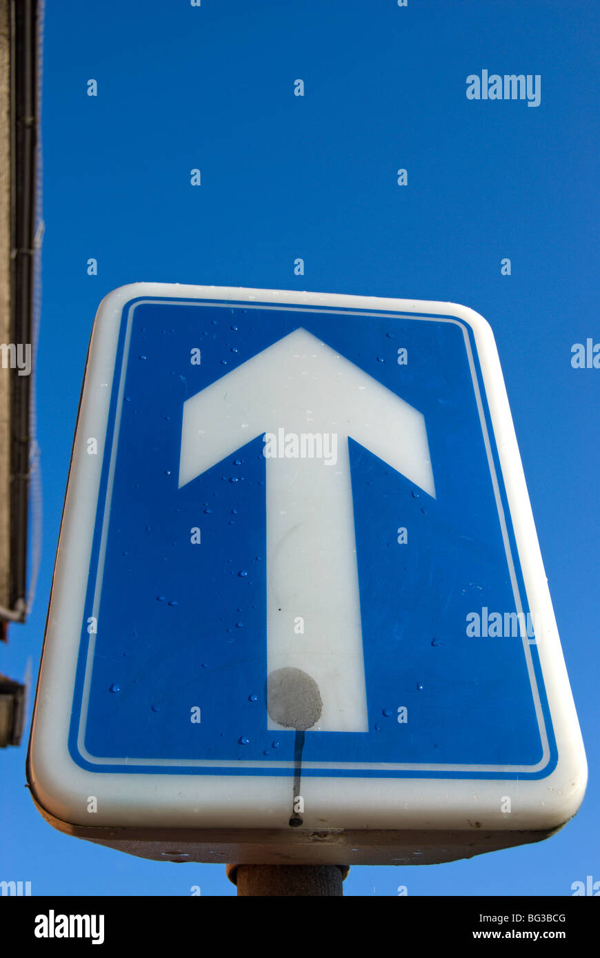 british one-way street sign, with white arrow on blue background Stock ... One Way Street Signs