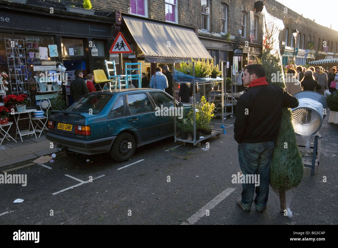 a man who has bought a christmas tree at columbia road flower market in london Stock Photo