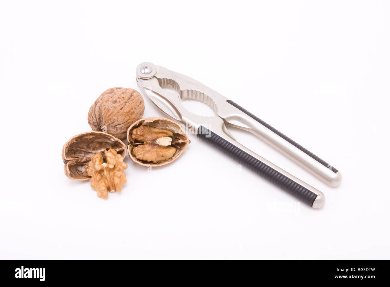 Walnut cracked open with nut cracker isolated against white background