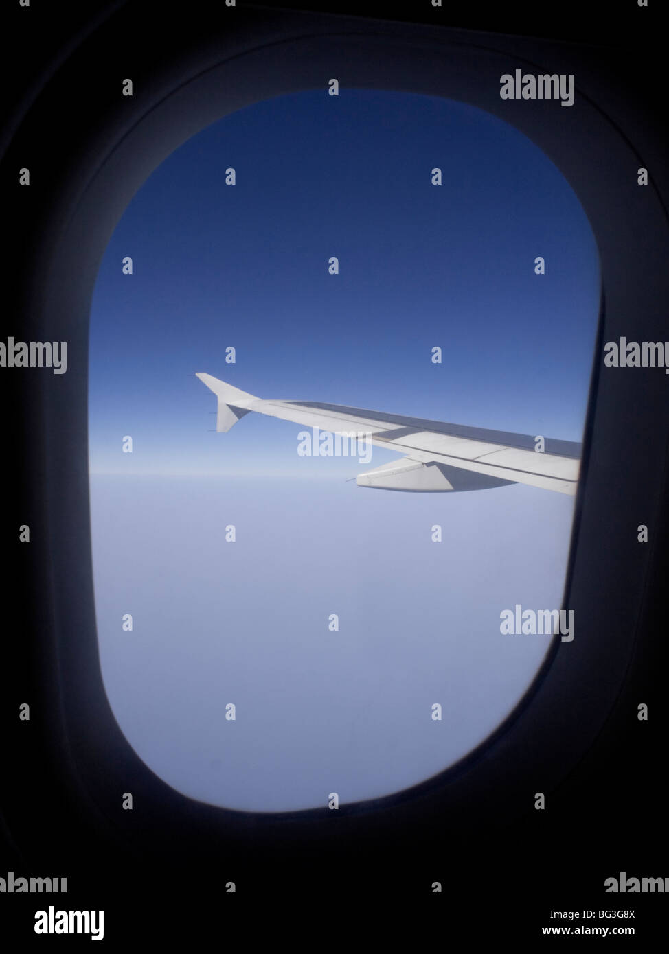 Air travel. Aerial view from the cabin window of an Airbus A319 passenger jet in flight at high altitude, showing the aircraft's wing Stock Photo