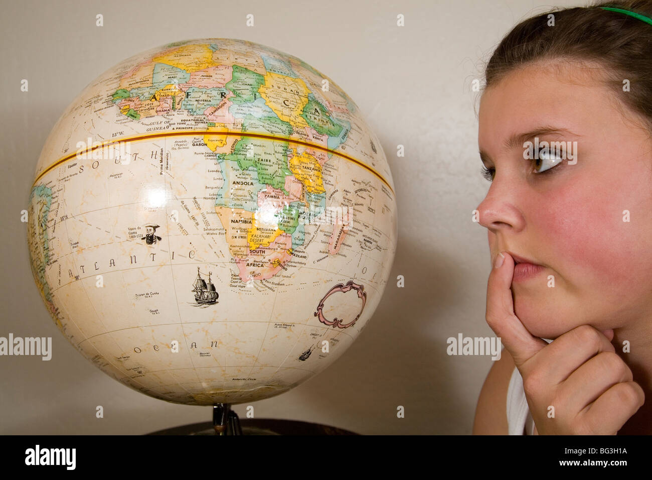 A teenager student looking at a world globe earth map of the world Stock Photo