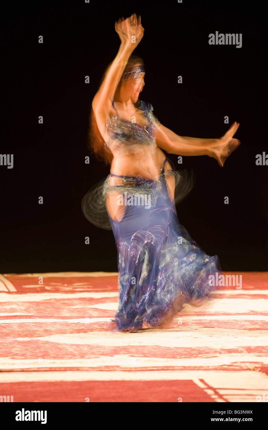 Belly dancer performing a traditional dance in the open air at night
