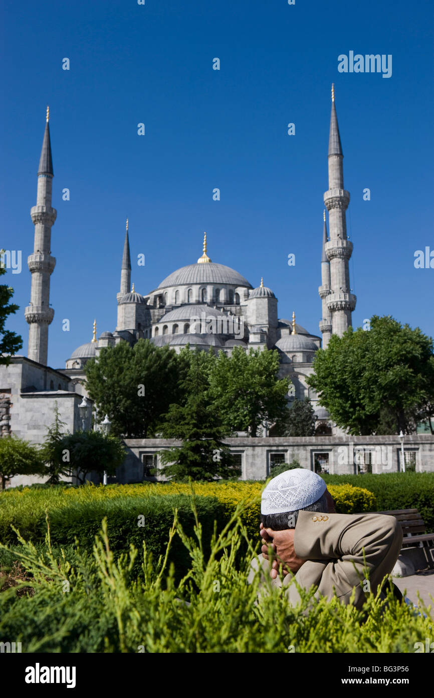 Turkish man with traditional headware relaxing in Sultanahmet Square in front of the Blue Mosque, Istanbul, Turkey, Europe Stock Photo