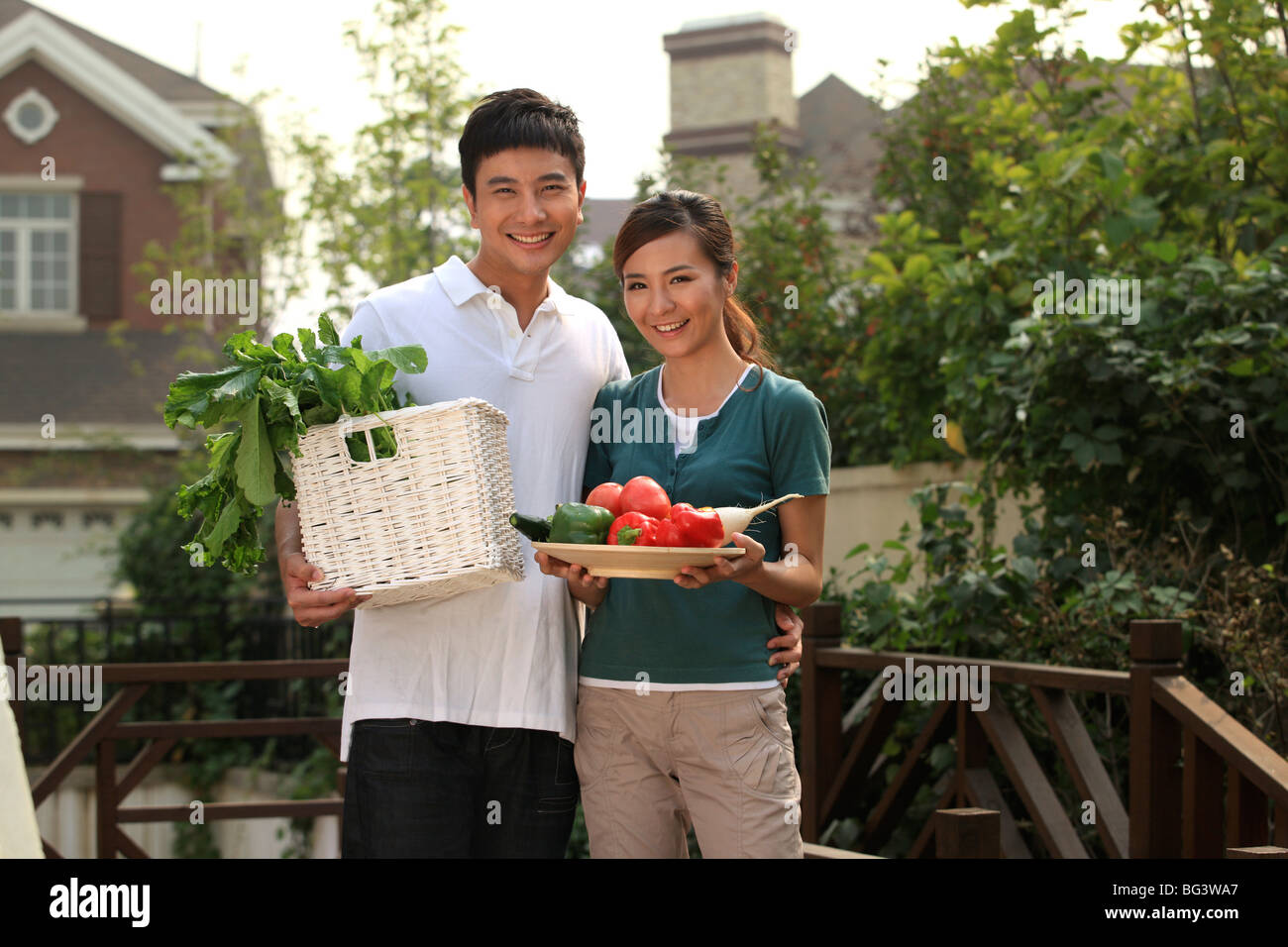 young couple holding vegetables and fruits Stock Photo - Alamy
