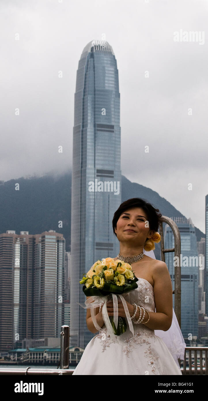 A bride poses for a photo shoot in front of Hong Kong island's skyline. Stock Photo