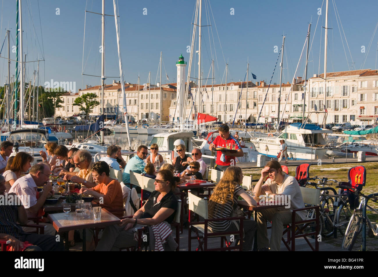 Open-air restaurant seating next to the ancient harbour at La Rochelle