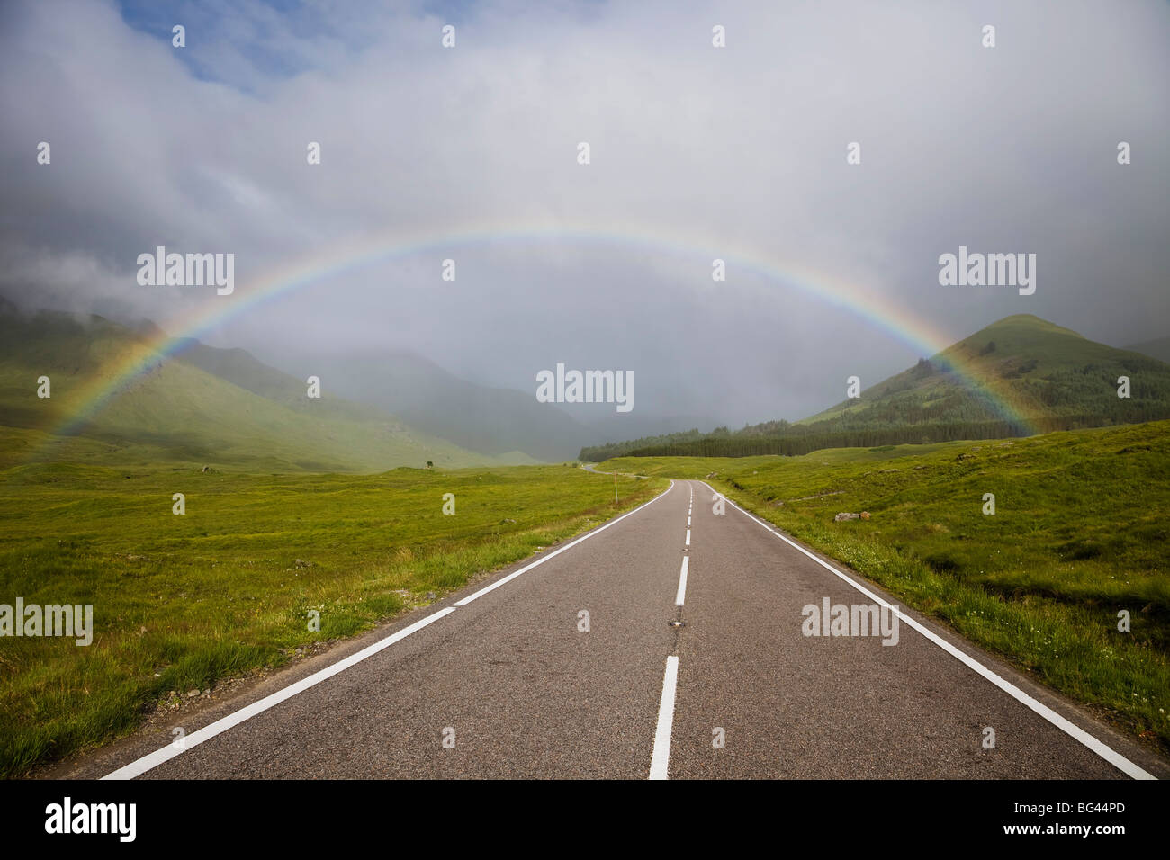Scotland, Highland Region, Empty Road and Rainbow Stock Photo