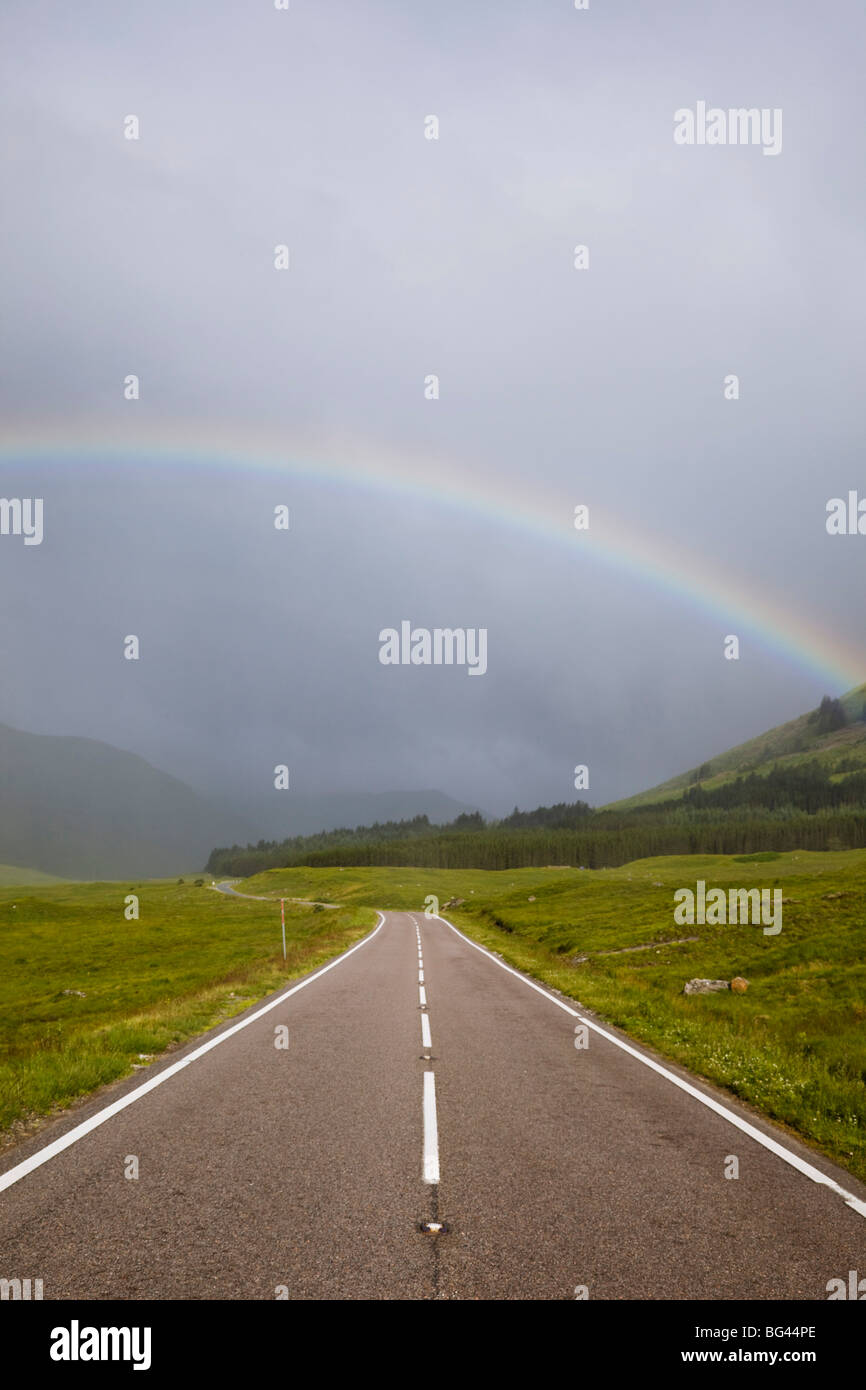 Scotland, Highland Region, Empty Road and Rainbow Stock Photo