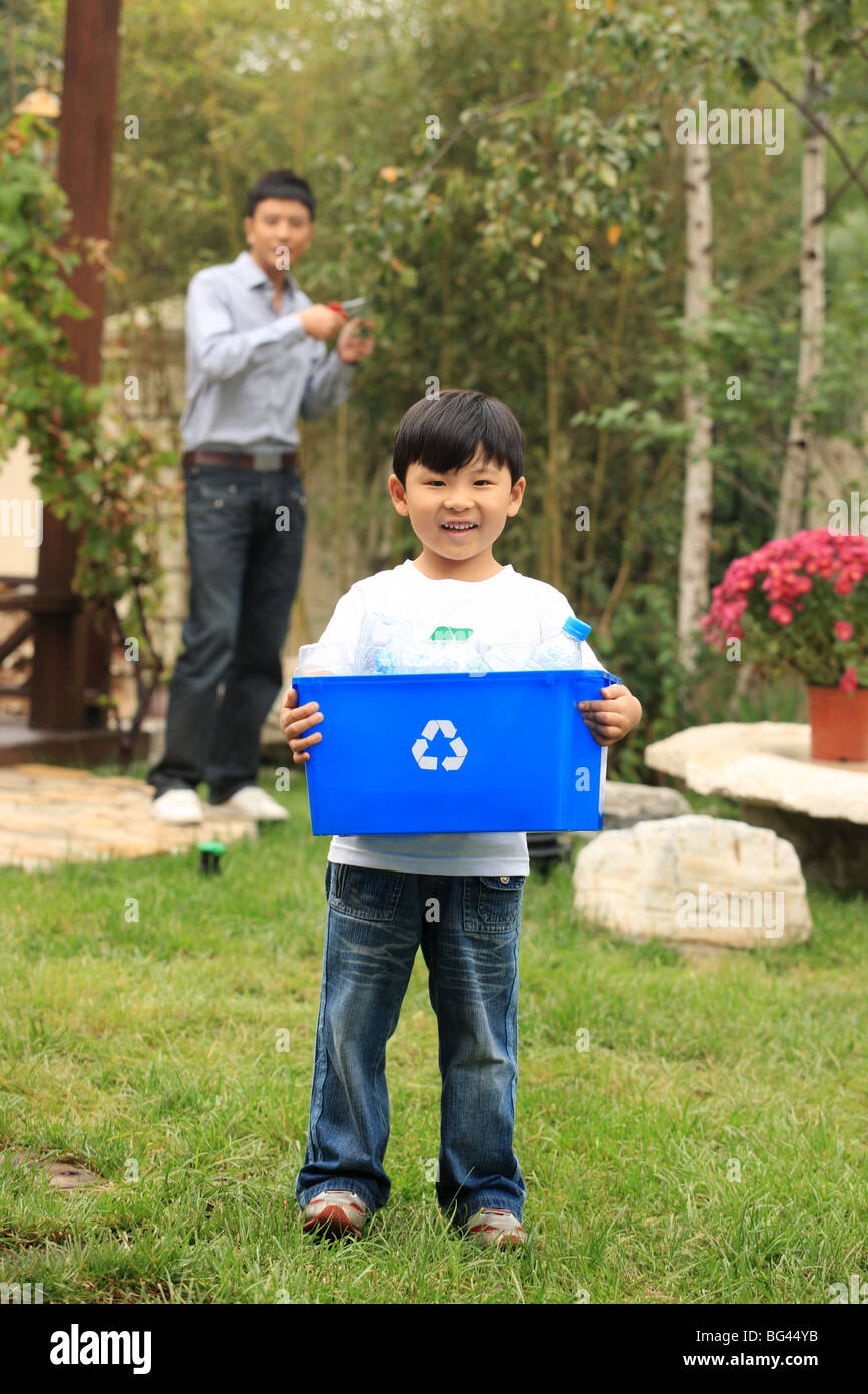 Two boys carrying recycling container hires stock photography and