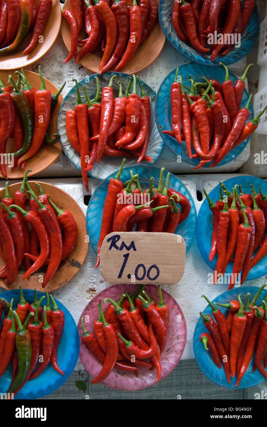 Colourful red chillies on blue plates on a market stall in Kuching