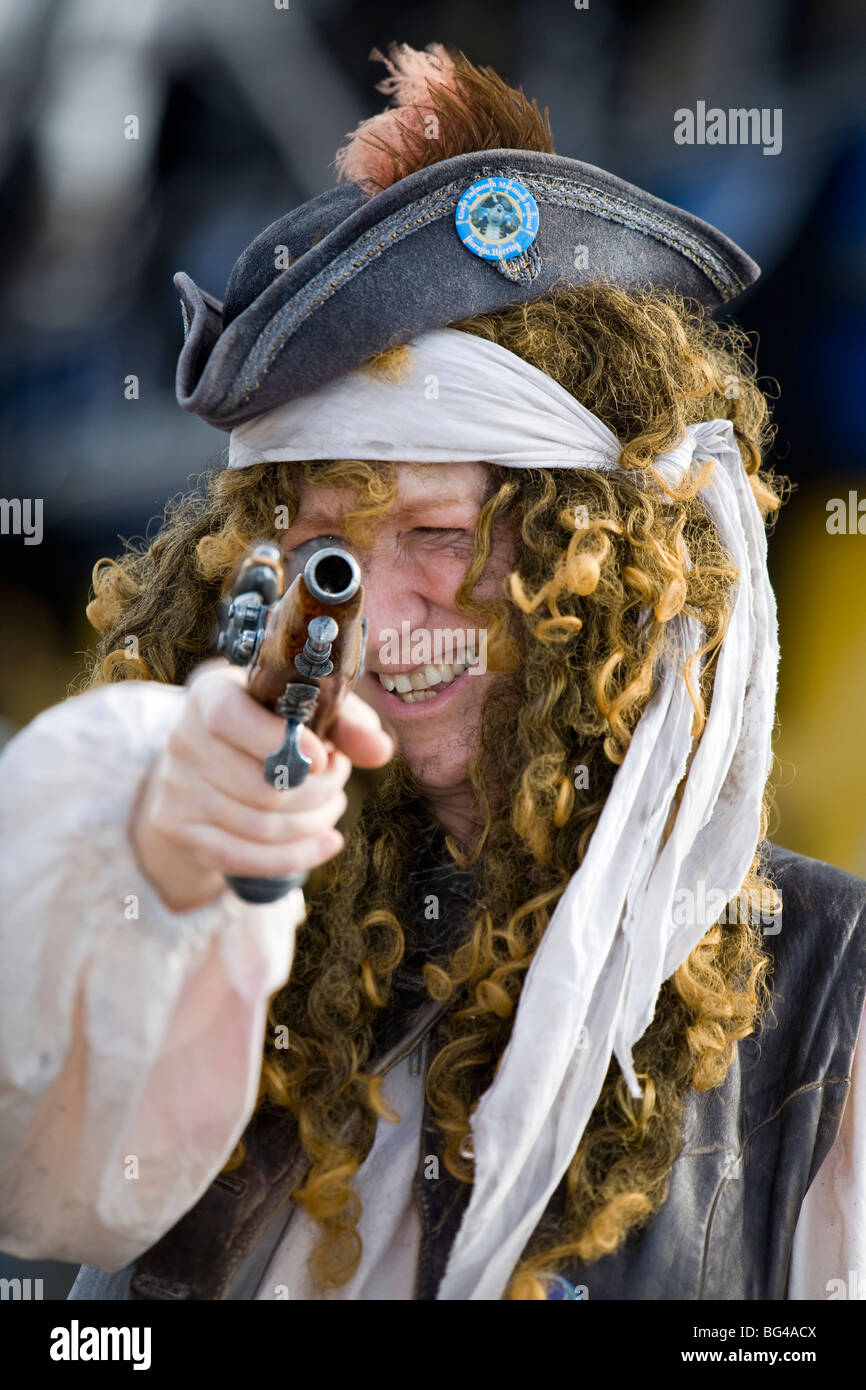 Pirate takes aim with pistol at maritime festival Stock Photo