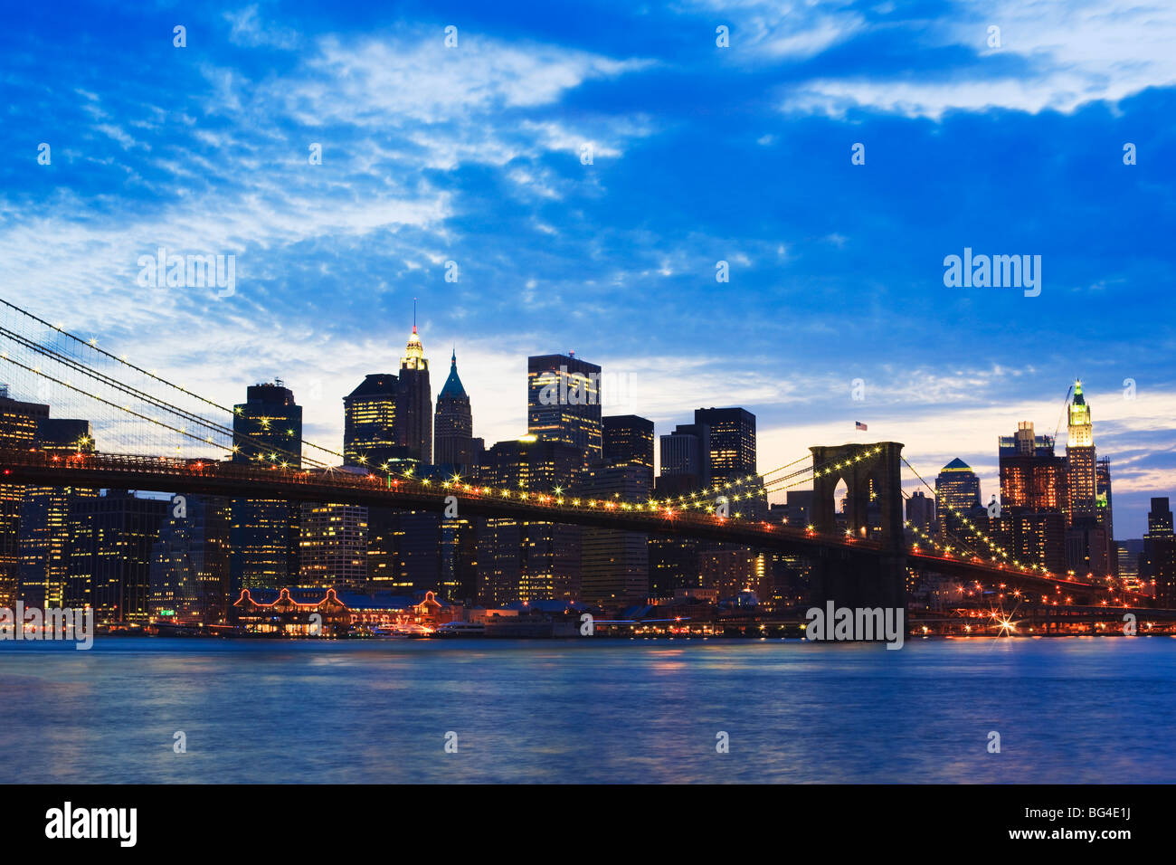 Brooklyn Bridge spanning the East River and the Lower Manhattan skyline at dusk, New York City, New York, USA Stock Photo