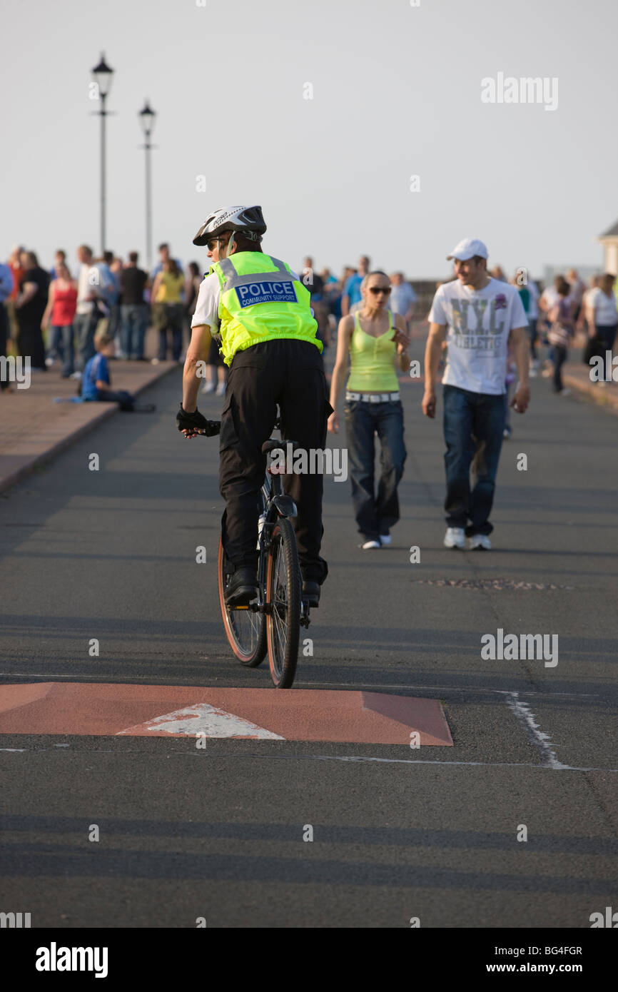 Female police officer on duty riding bicycle Stock Photo