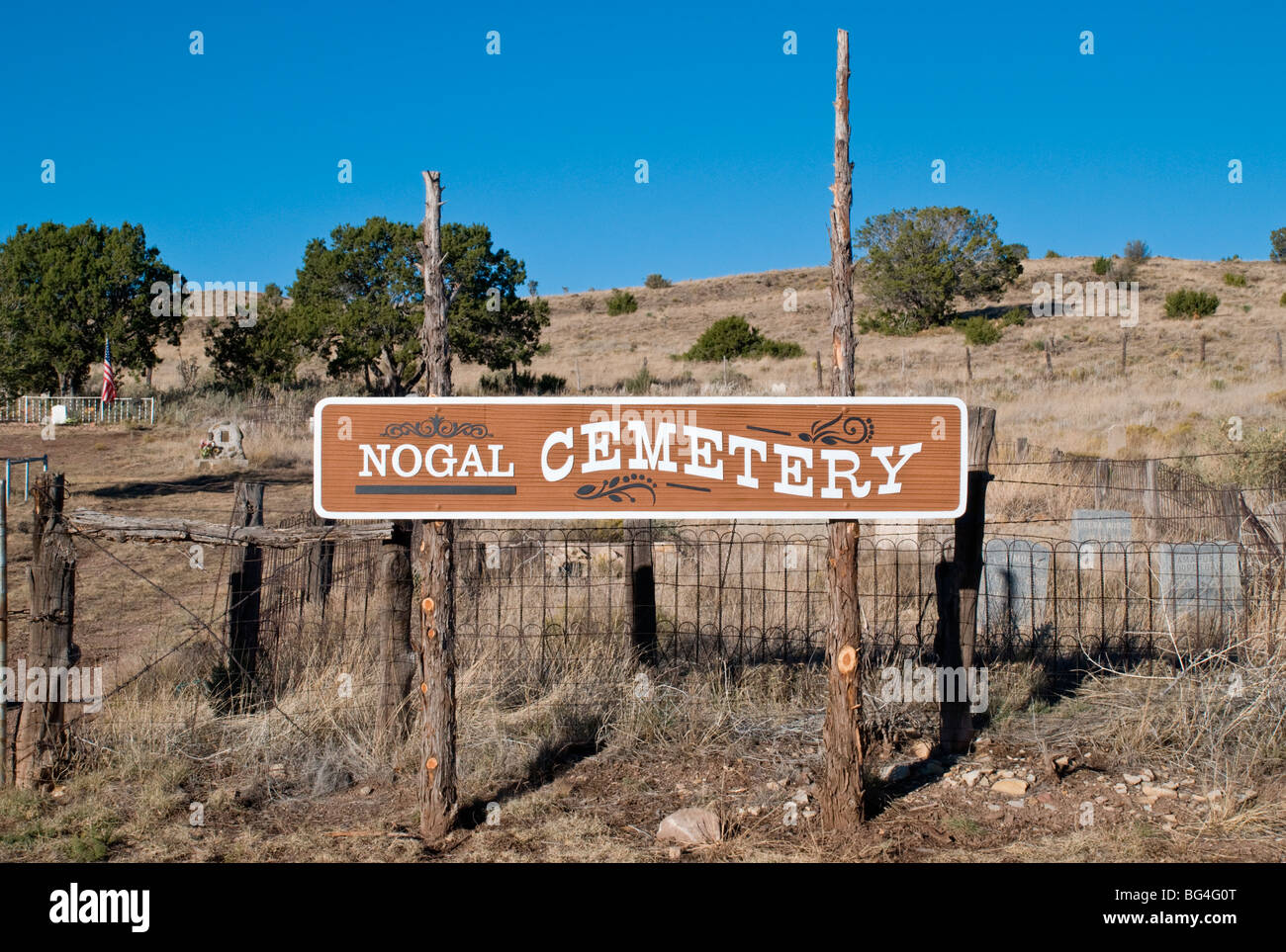 The Nogal cemetery is a tiny cemetery, hidden amongst high grass & tumbleweeds outside the small town of Nogal, New Mexico USA. Stock Photo
