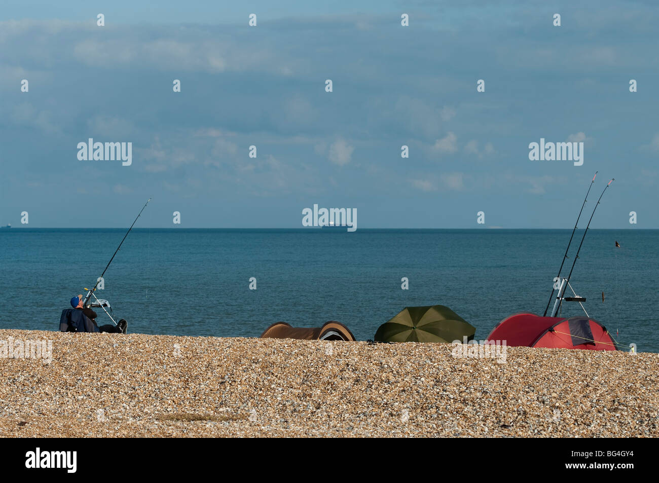 Sea angler waits to catch fish at Dungeness, Kent, England Stock Photo