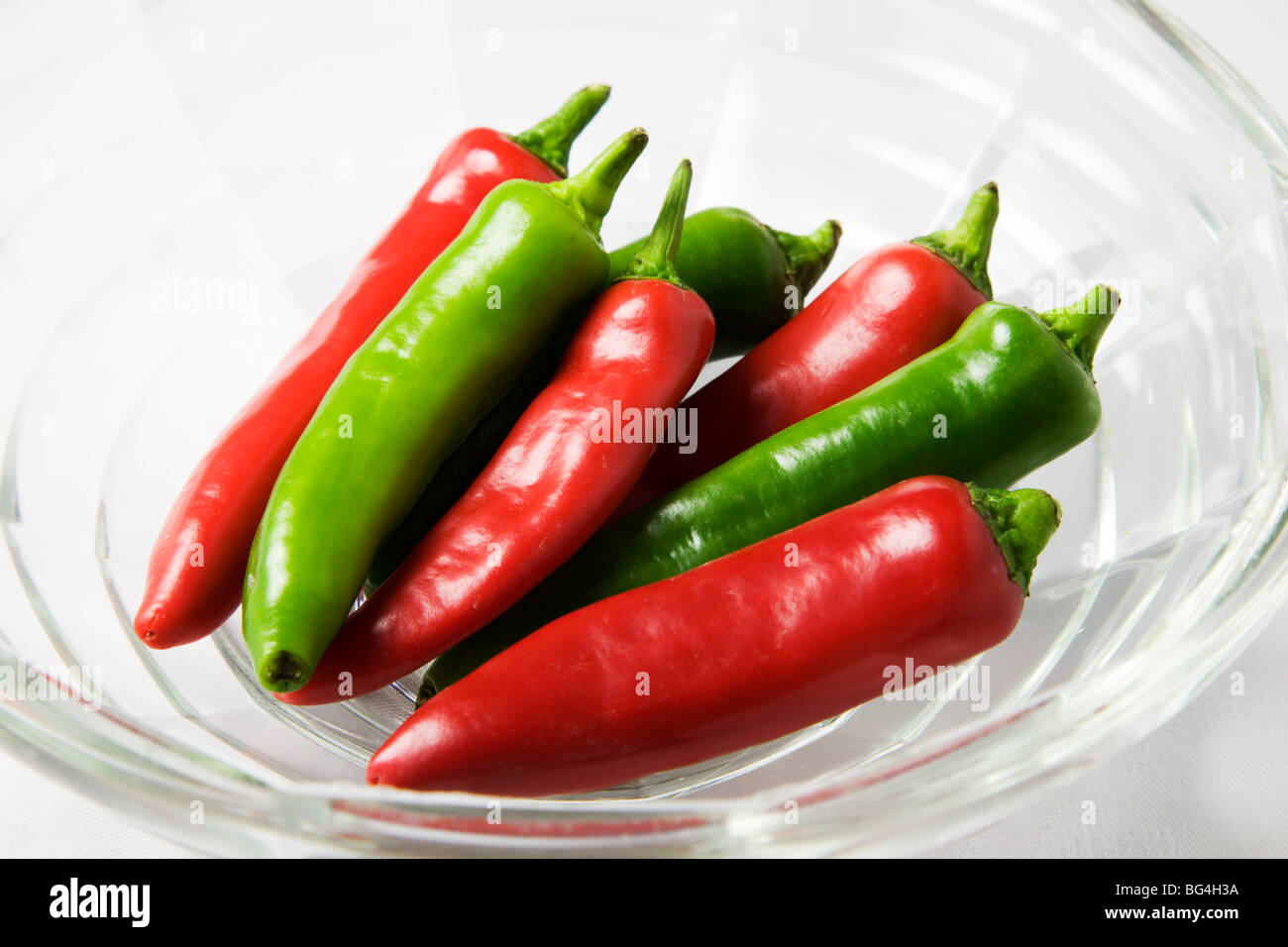 Red and Green Chili Peppers in a Glass Bowl Stock Photo