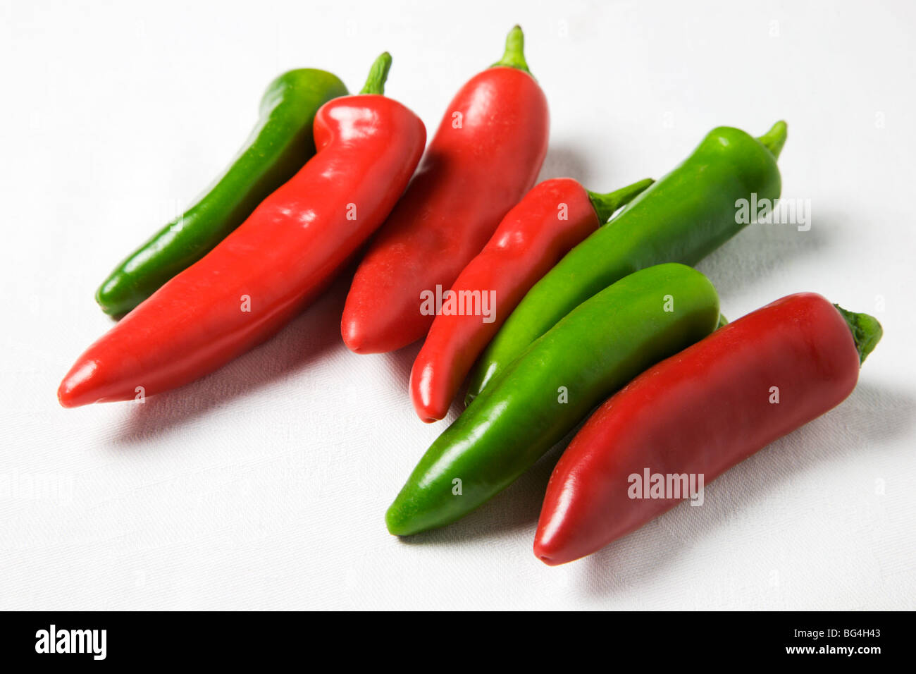 Red and Green Chili Peppers on a White Background Stock Photo