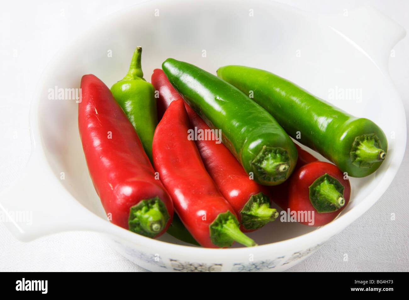 Red and Green Chili Peppers in a White Dish Stock Photo