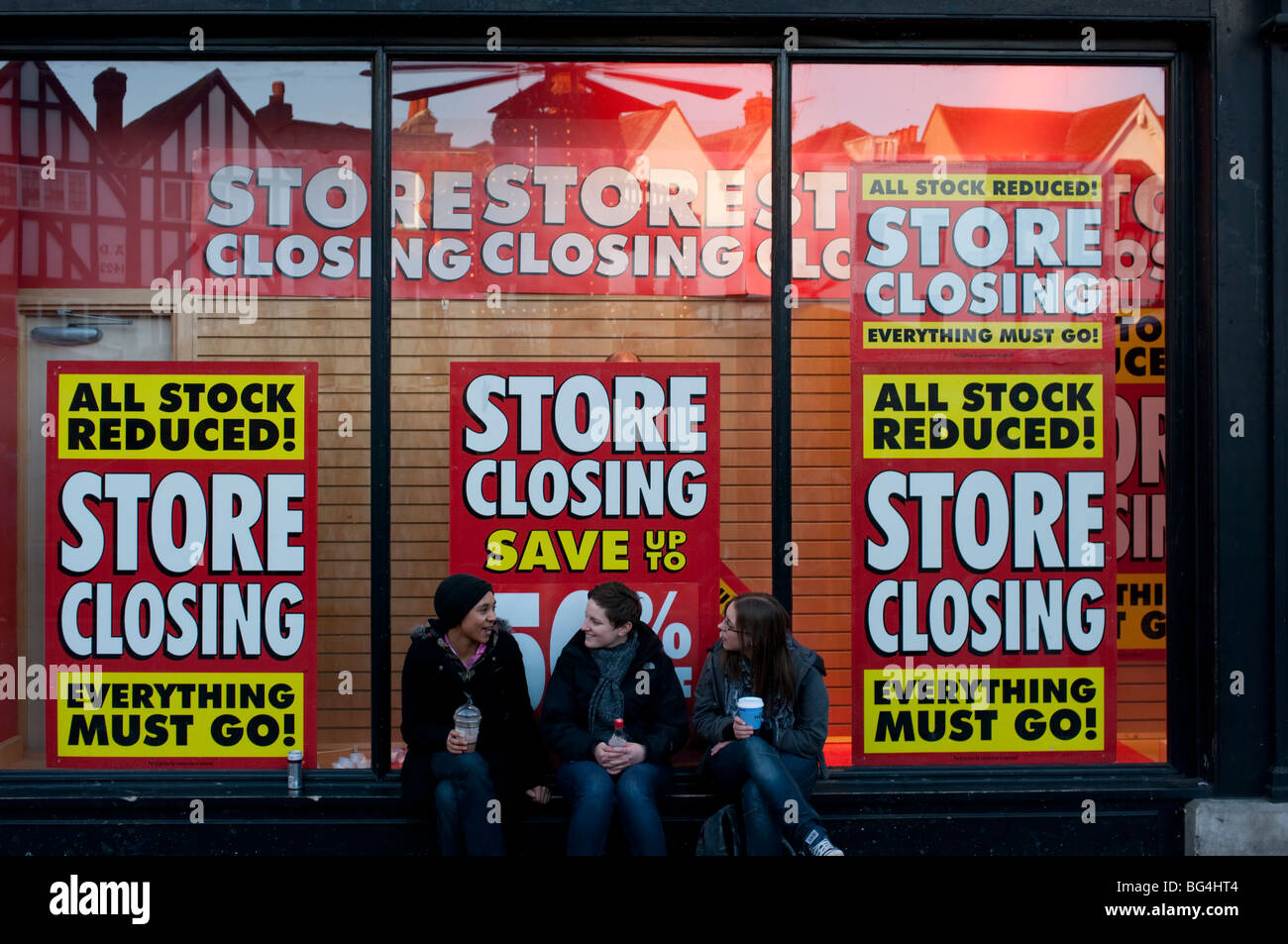 shop window signs notifying store closing down and stock liquidation in a sign of the times Stock Photo