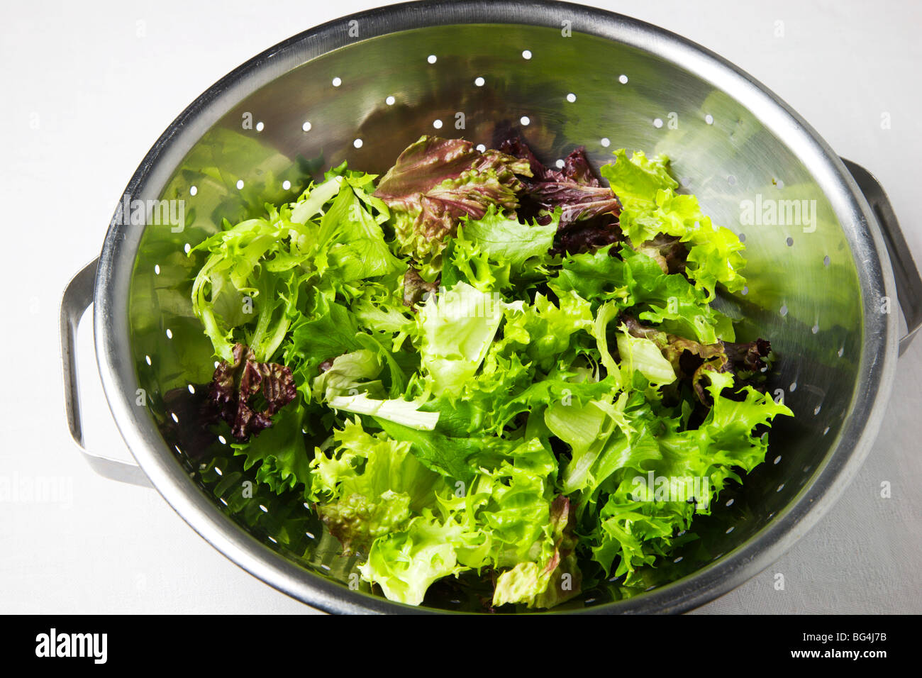 Mixed Frilly Lettuce Leaves in a Colander Stock Photo