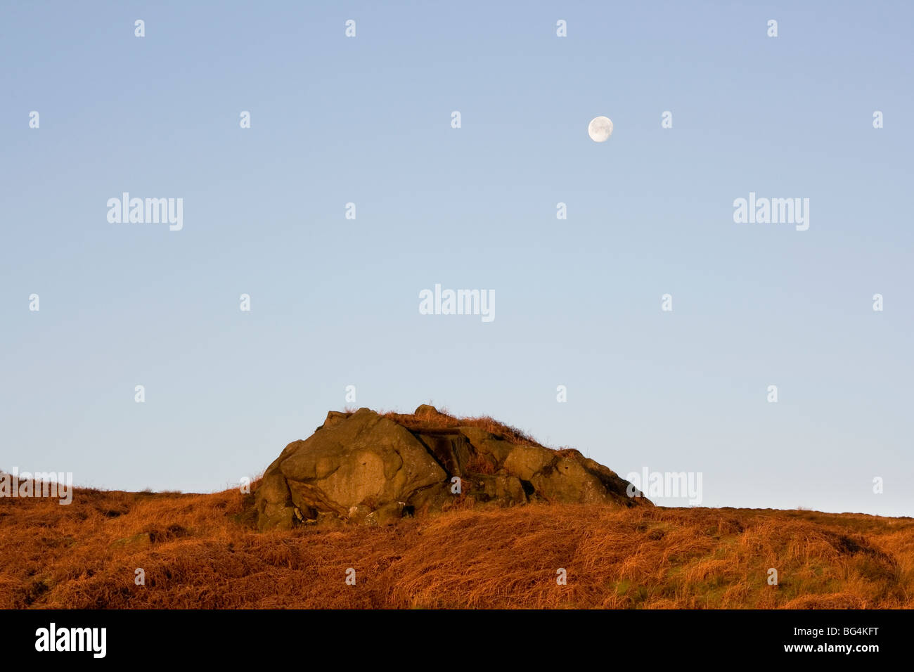 Dawn, and the moon still shines above rocks on Embsay Moor, in North Yorkshire, UK Stock Photo