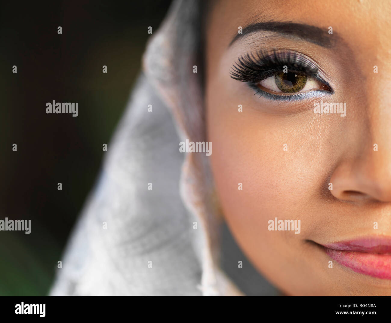 A close-up of a traditional Malaysian dancer's face, with long lashes and stage Make-Up. Stock Photo