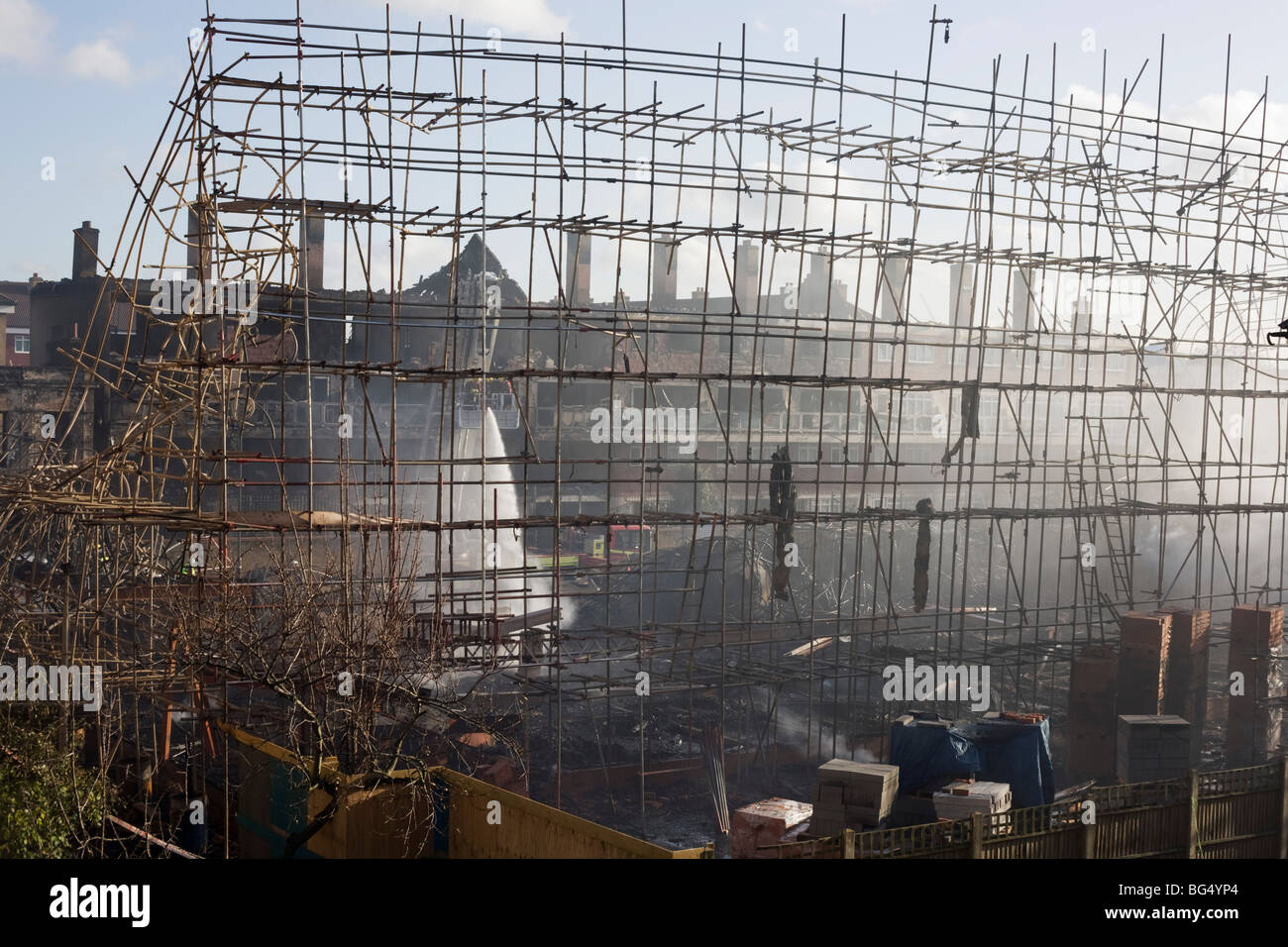 The smouldering remains of a construction site after an inner-city estate fire in south London. Stock Photo