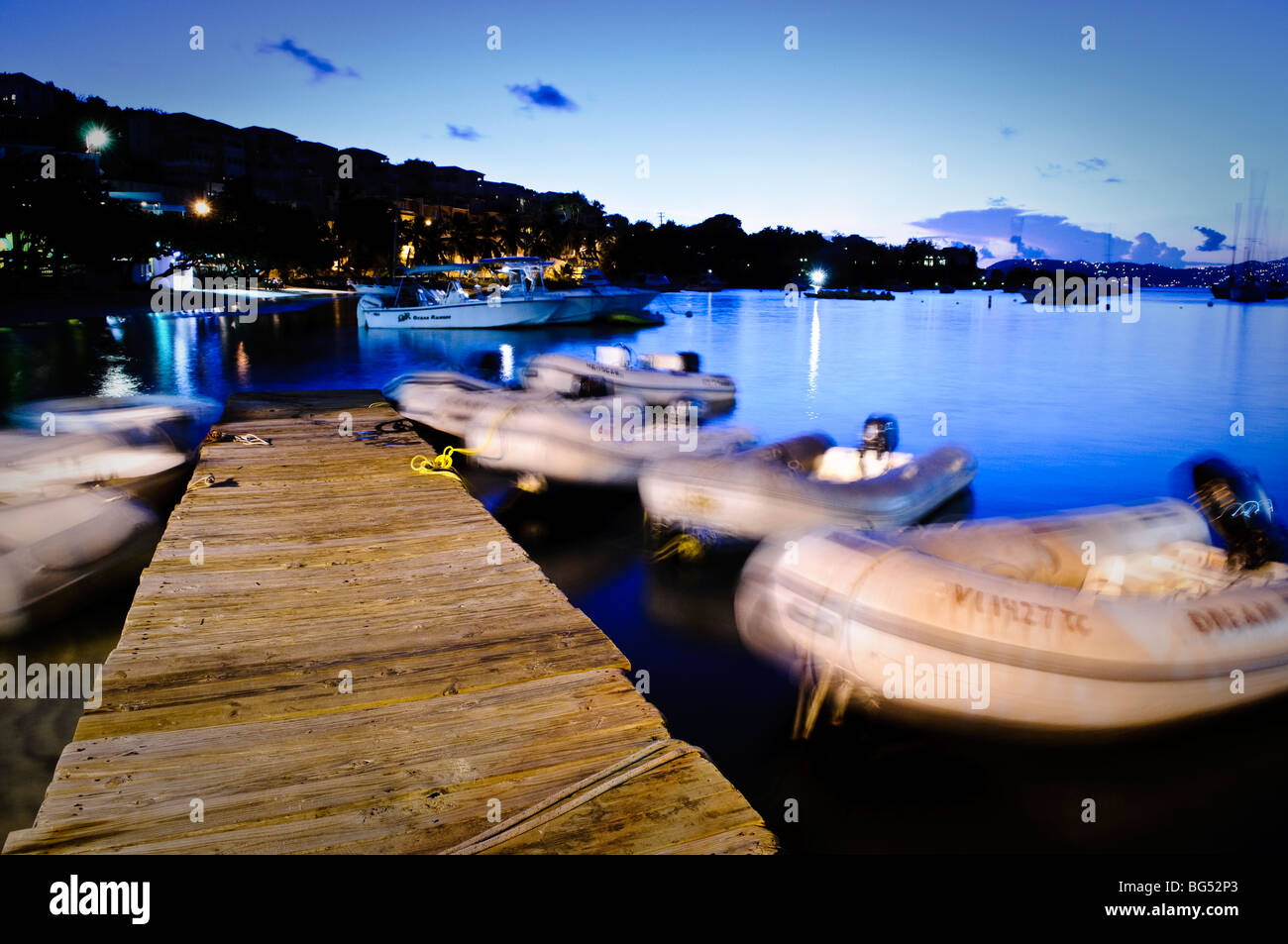 ST JOHN, US Virgin Islands - Pier of Cruz Bay Harbor on the Caribbean island of St John in the US Virgin Islands at dusk with motion blur of boats Stock Photo