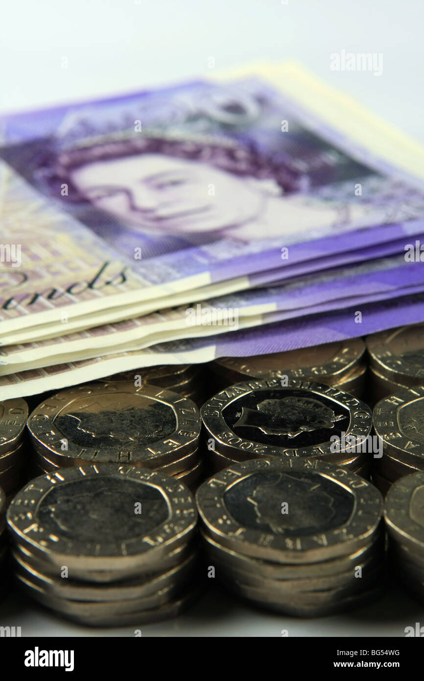 £20 notes on stacks of 20p coins Stock Photo
