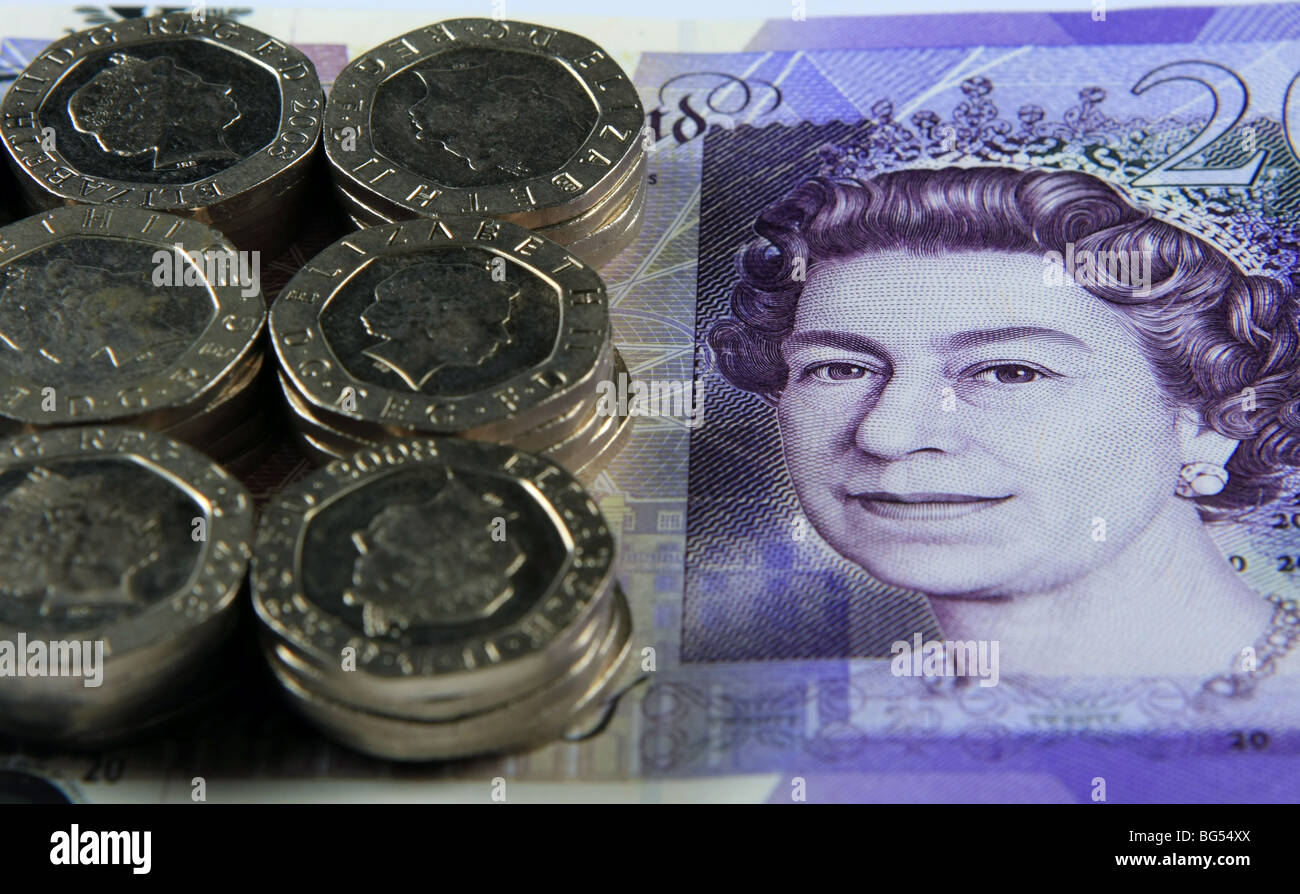 stacks of 20p coins on a £20 note Stock Photo