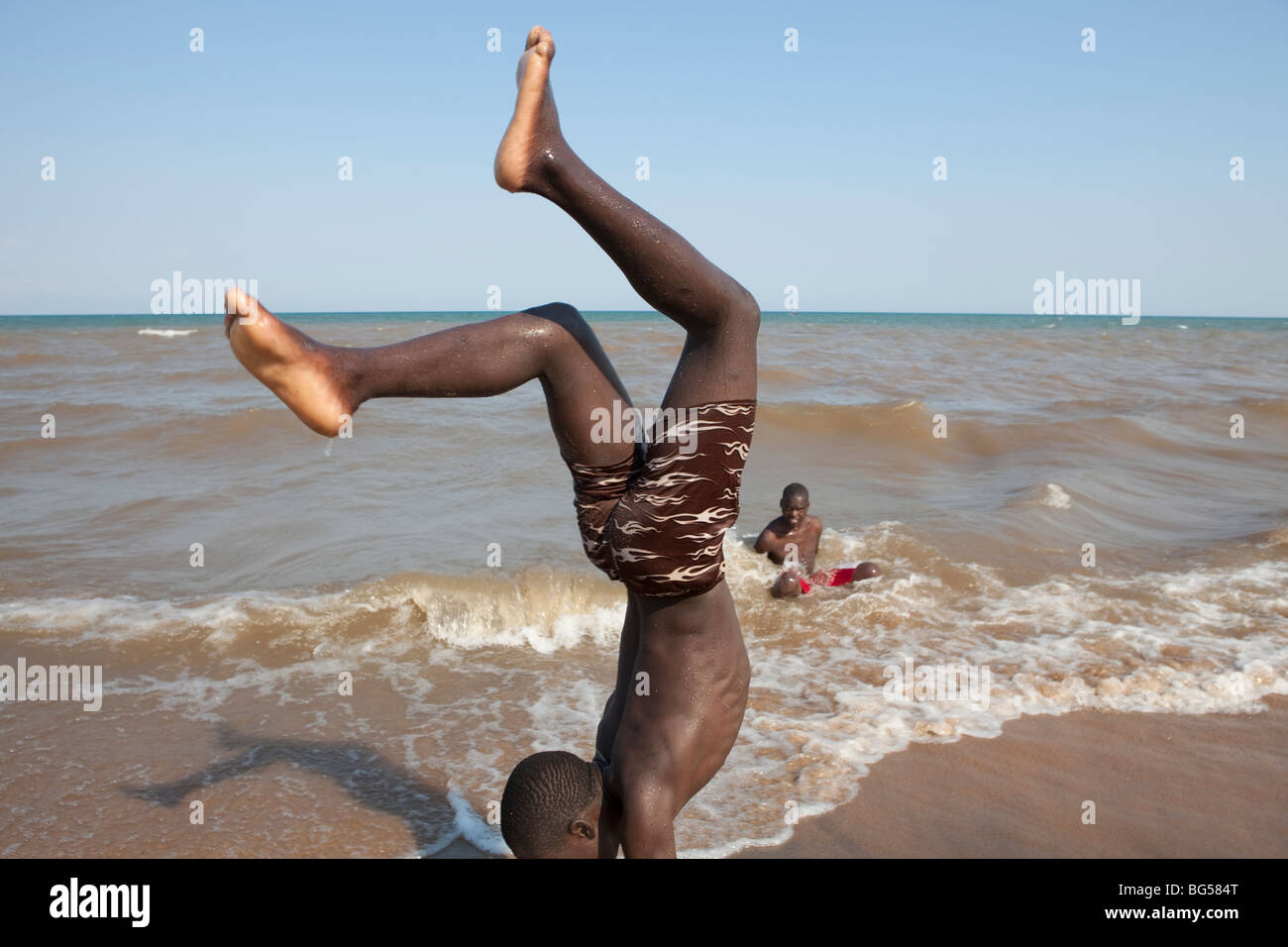 Youths exercise on the shores of Lake Malawi near the town of Karonga, Malawi in Southern Africa. Stock Photo