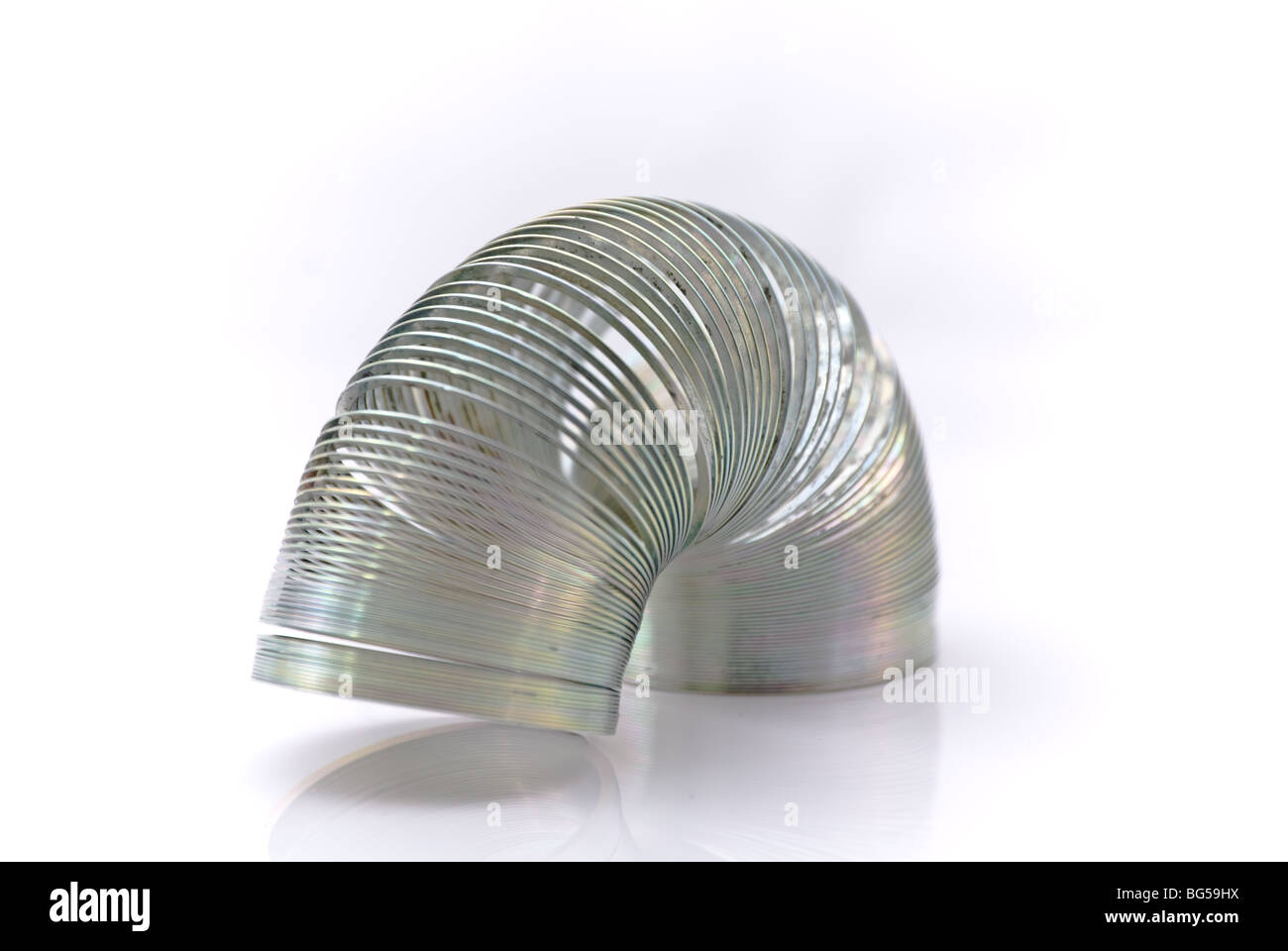 A spring of metal, tightly coiled into a near arch Stock Photo
