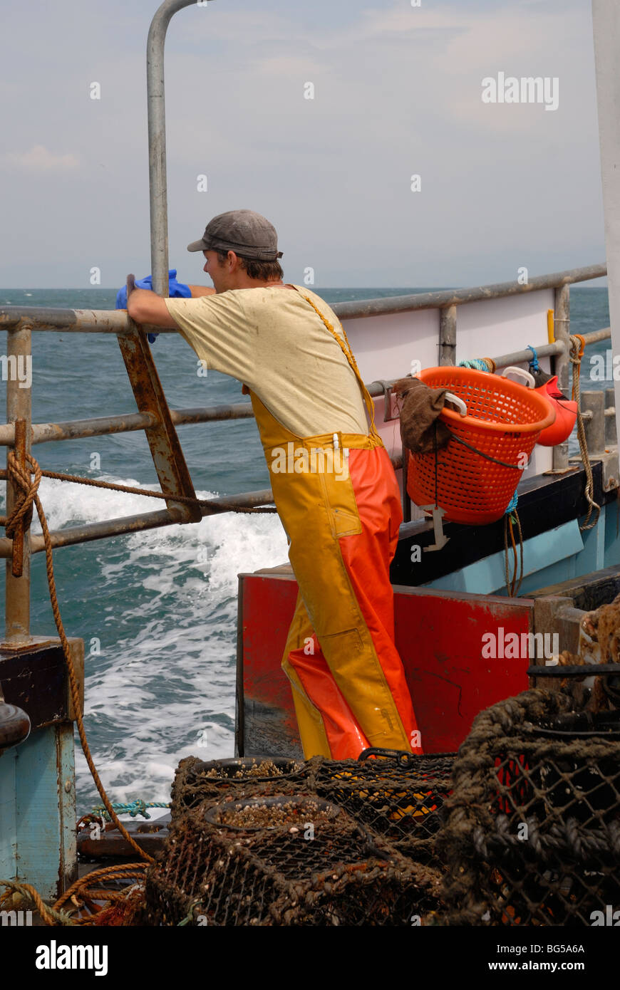 Fisherman aboard a Lobster fishing boat, waiting to 'shoot' the pots, Cardigan Bay, Wales. Stock Photo