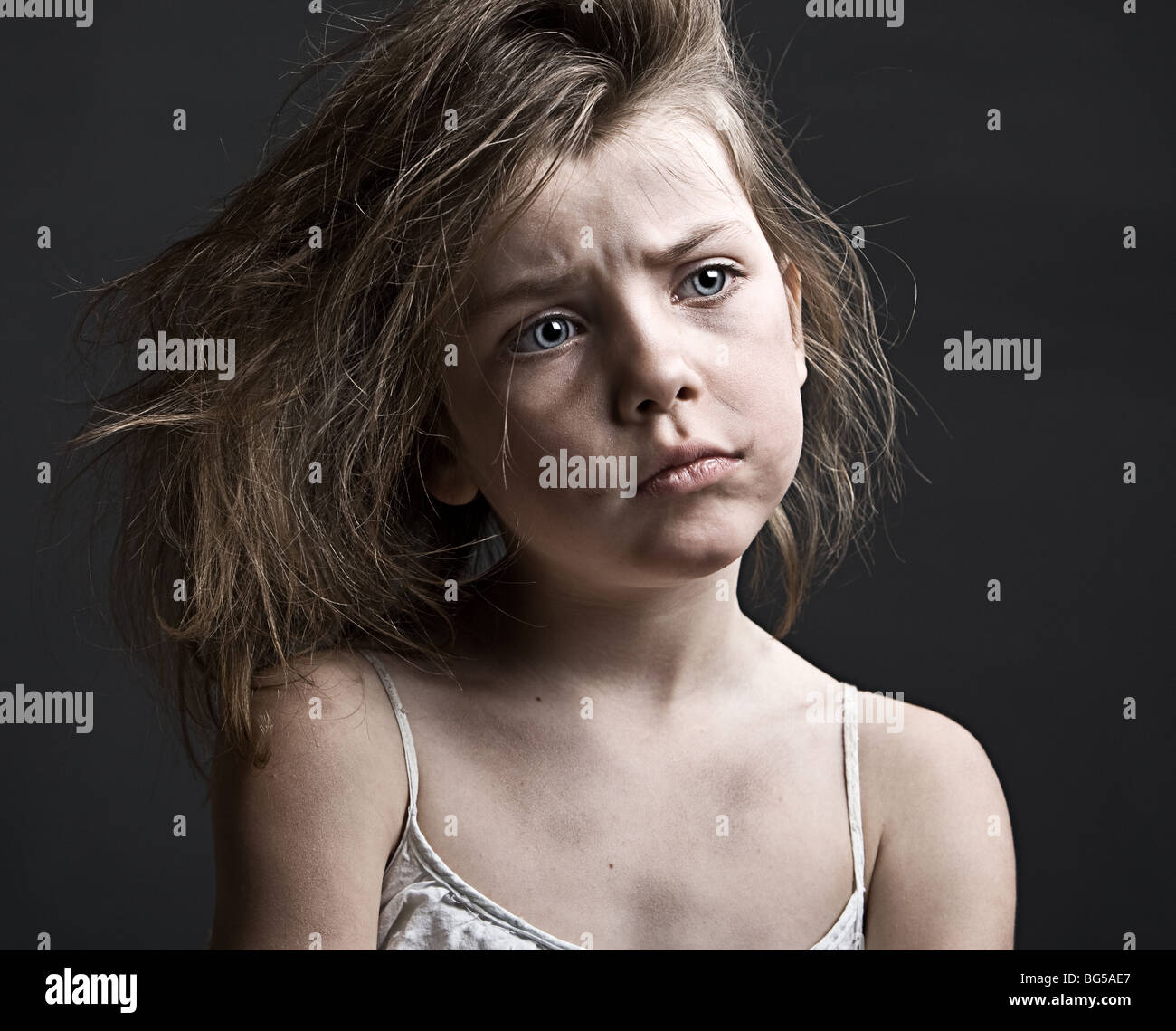 Powerful Shot of a Messy Child against a Grey Background Stock Photo