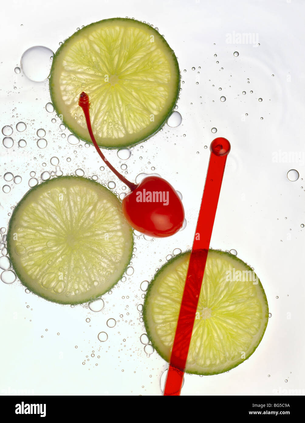 Cherry and lime wheels with stir stick and soda water Stock Photo