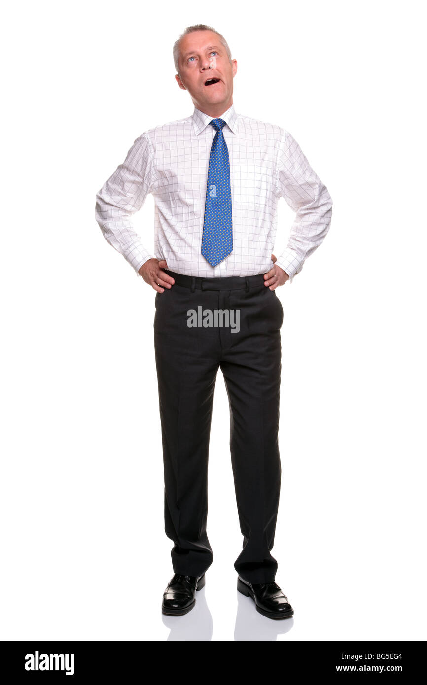 A mature businessman with his hands on his hips yawning, isolated on a white background. Stock Photo