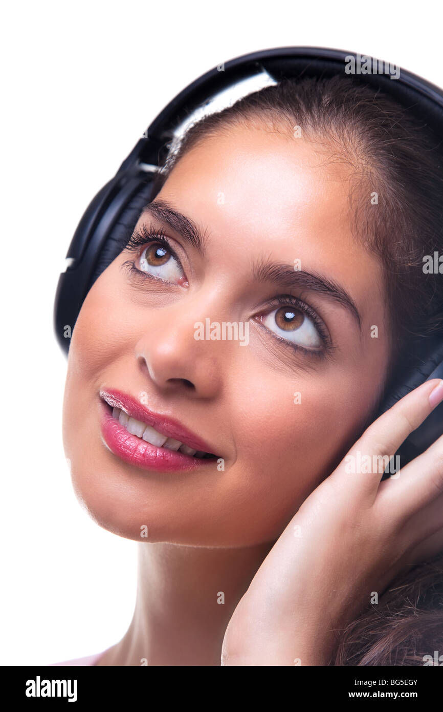 Headshot of a young woman wearing headphones listening to music, isoalted on white background. Stock Photo