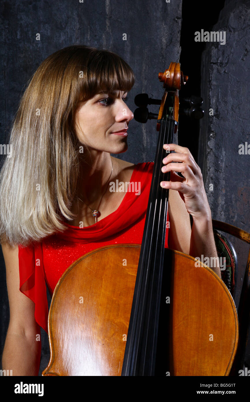 Beautiful cello musician on grey wall background Stock Photo