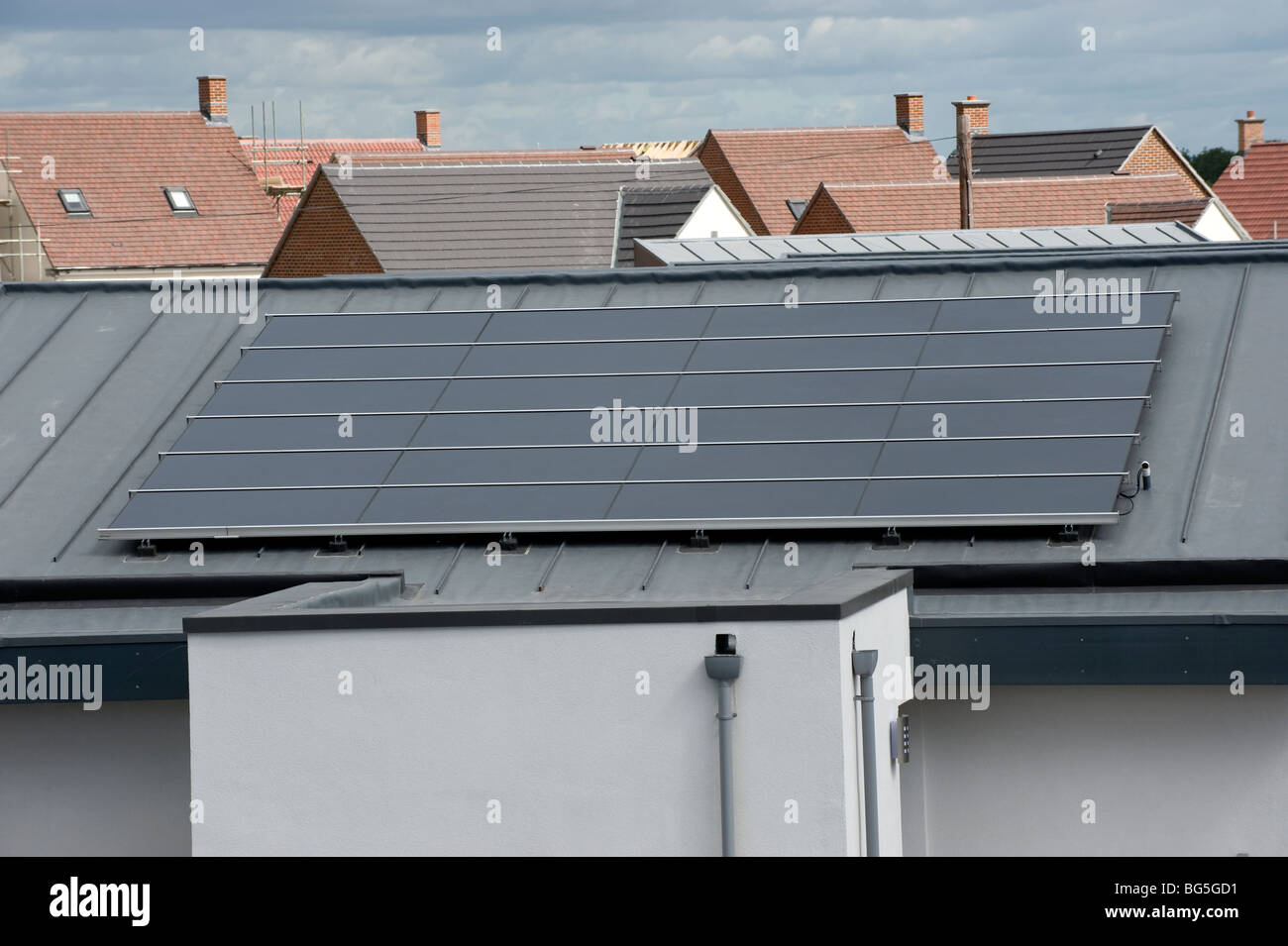Roof-mounted photo voltaic solar panels on a new housing estate Stock Photo