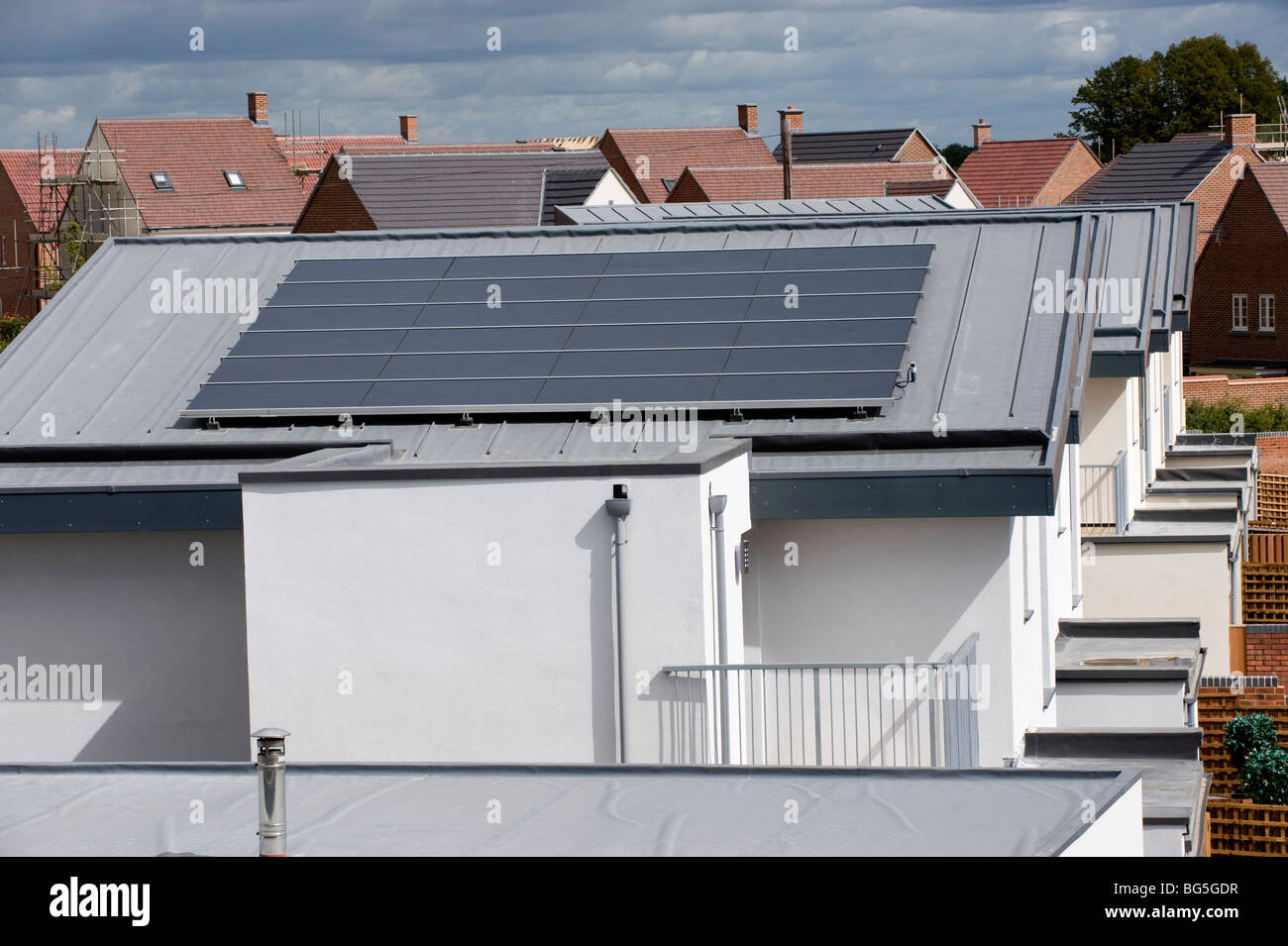 Roof-mounted photo voltaic solar panels on a new housing estate Stock Photo