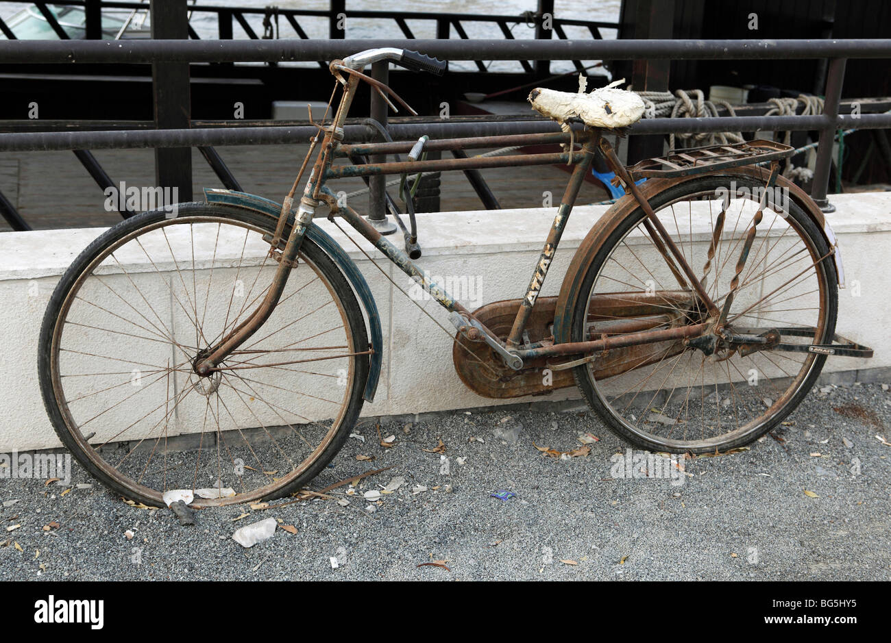 A rusty bicycle leaned on a balustrade, Dubai, United Arab Emirates Stock Photo