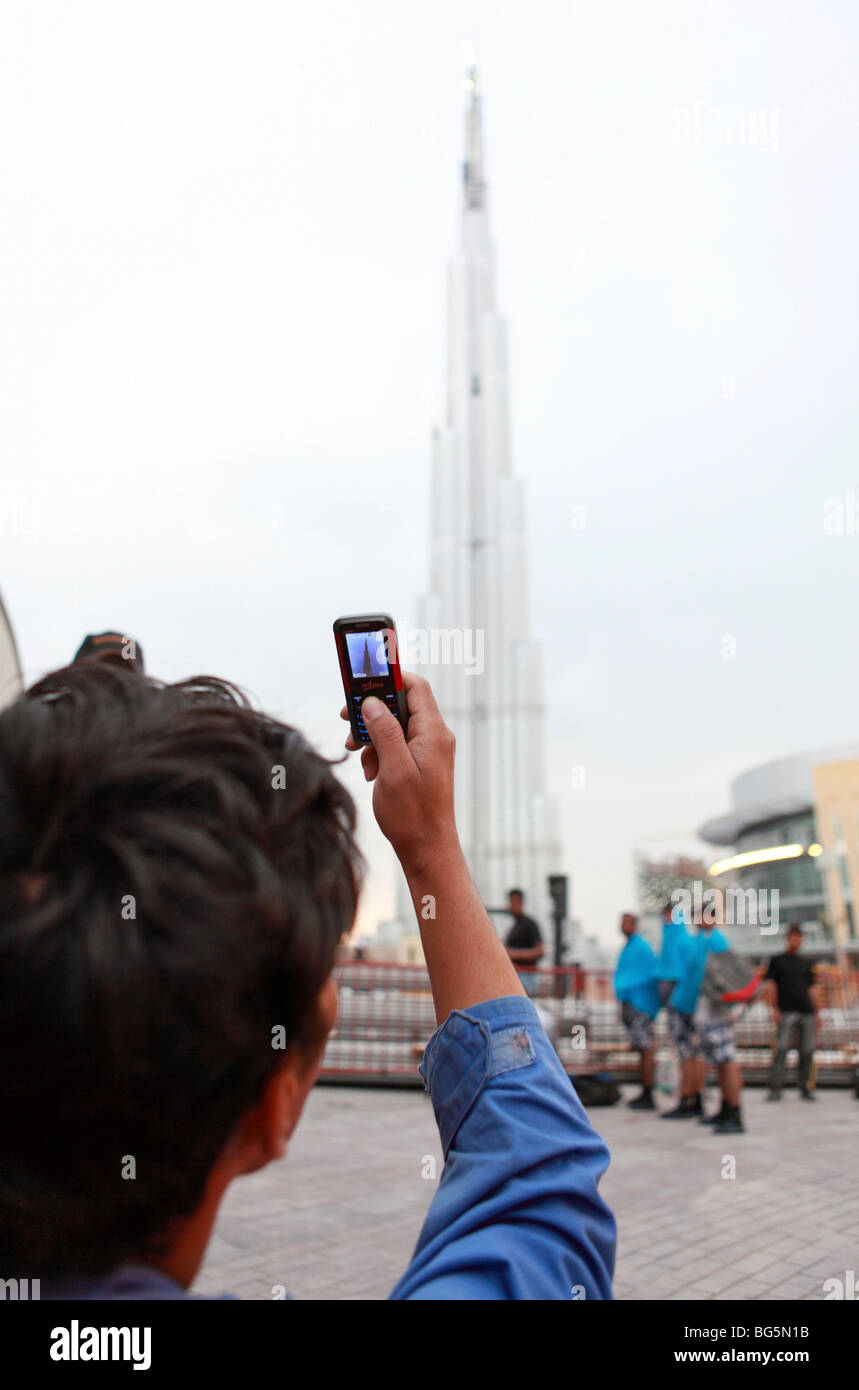 A man photographing Burj Dubai with a mobile phone, United Arab Emirates Stock Photo
