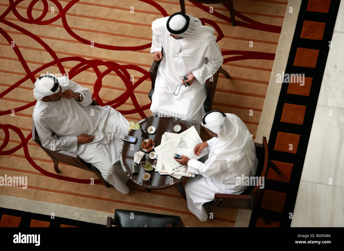 Arabs sitting in the lobby of the Tower of the Emirates Hotel, Dubai, UAE Stock Photo