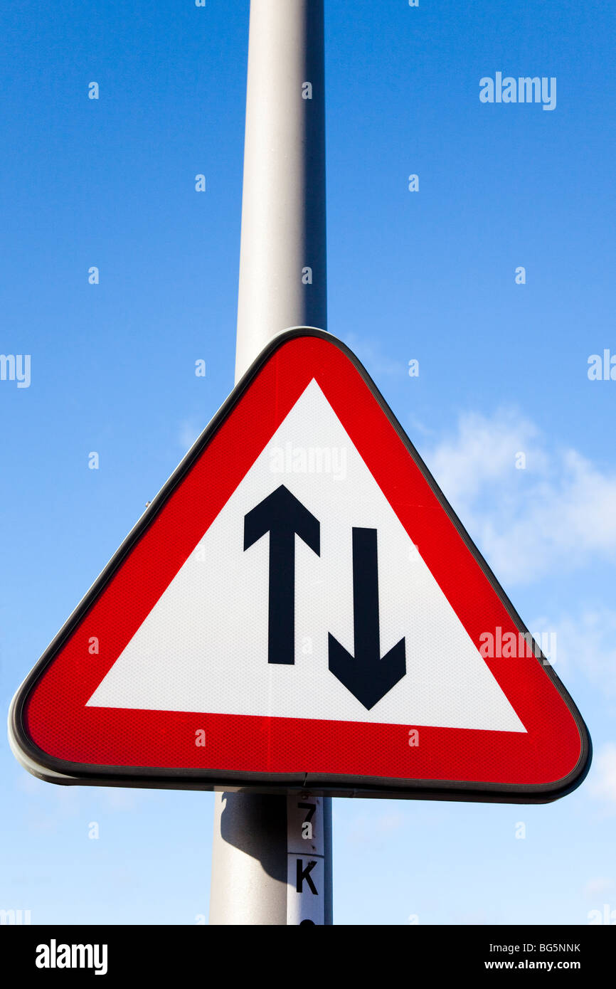 UK road sign, 'Two way traffic', against blue sky. Stock Photo