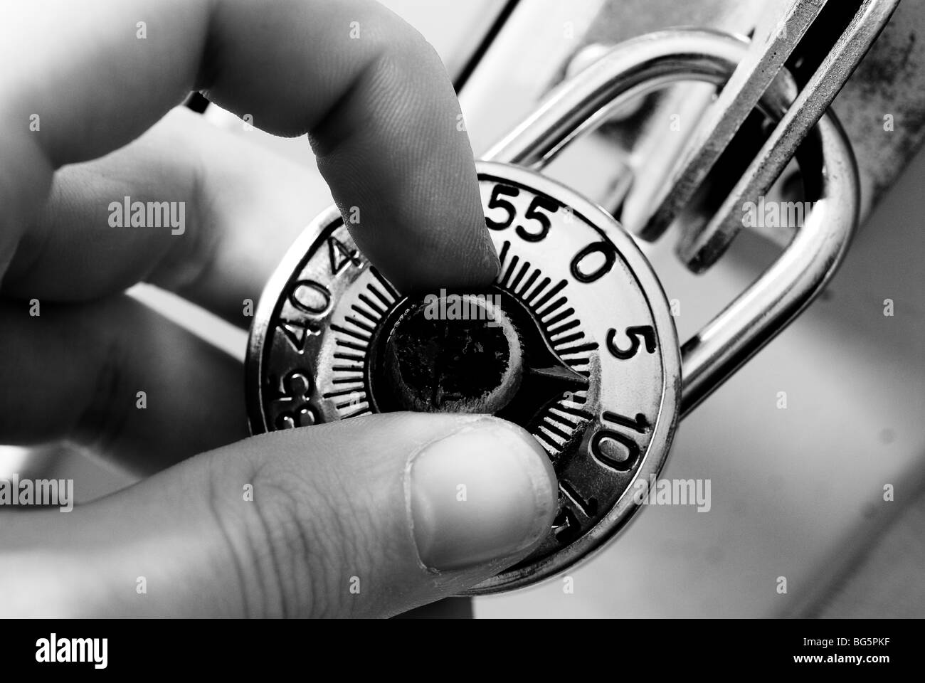 Fingers adjusting the dial on a traditional combination lock. Stock Photo