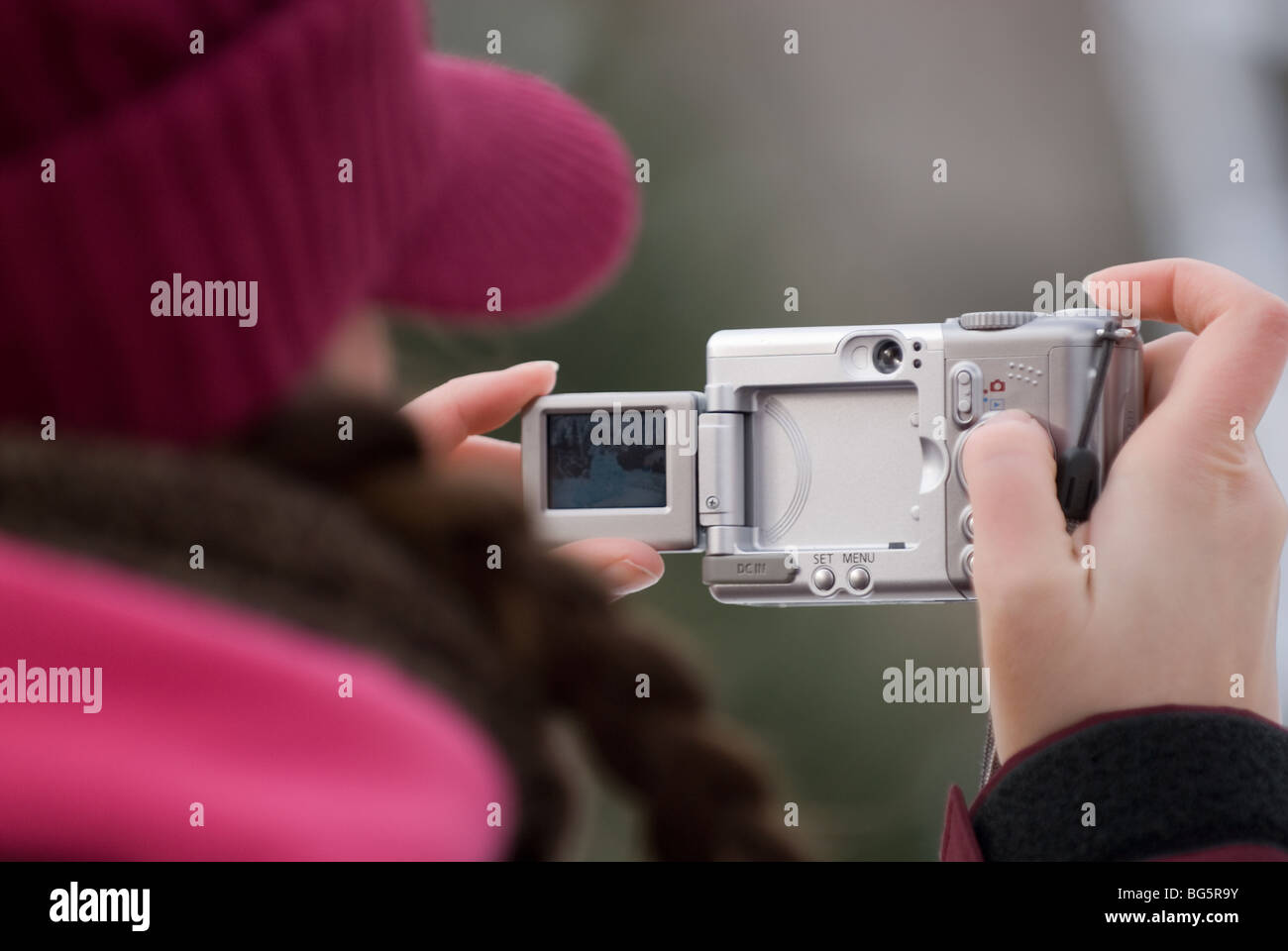 A woman uses the articulated LCD screen on the back of her digital